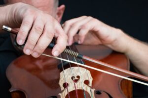 man practicing the cello, cello, bow .jpg